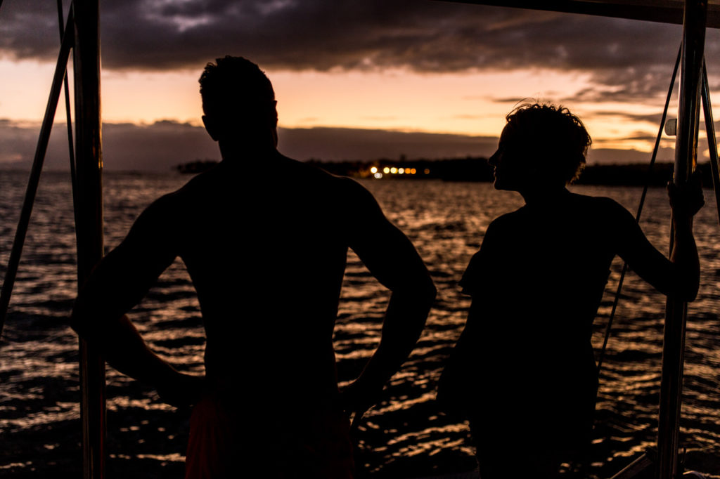 Silhouette von zwei Crewmitglieder abends in der Karibik