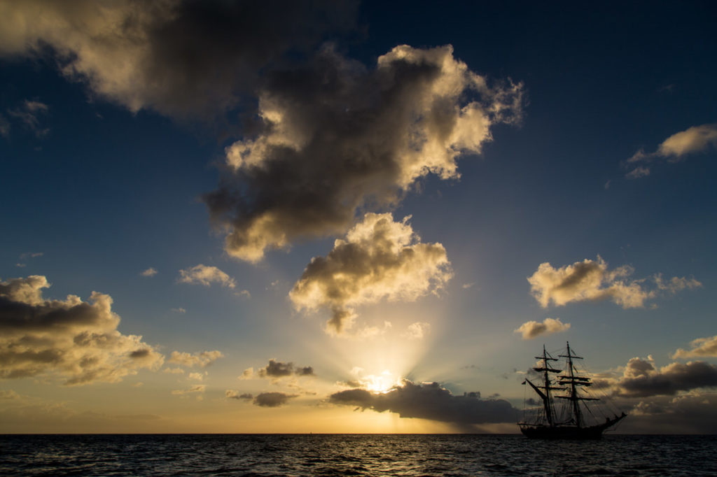 Historisches Segelschiff als Silhouette vor tiefstehender Sonne