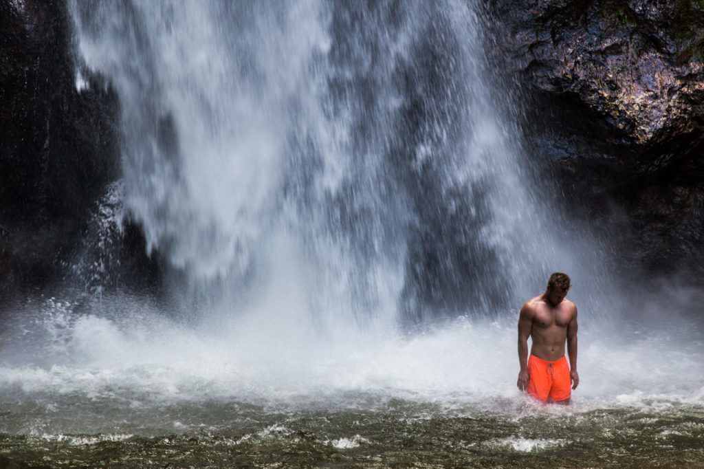 Muskulöser Mann vor Wasserfall auf Domenica