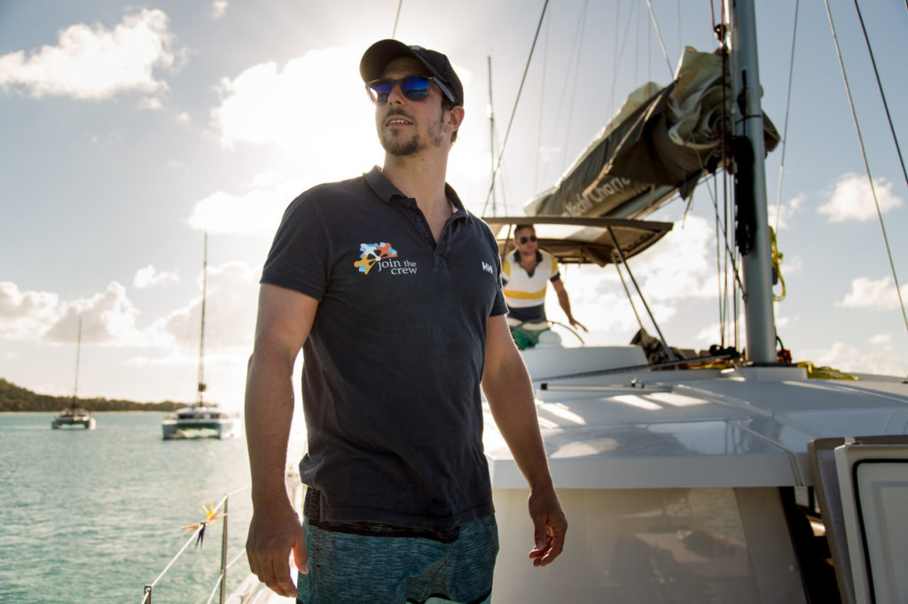 Skipper mit Join-the-Crew Polo-Shirt auf Segelboot