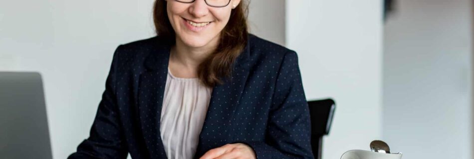 Übersetzerin mit Wörterbuch, Laptop und Kaffeetasse